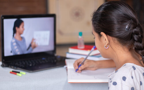 A young student at a laptop taking a virtual class