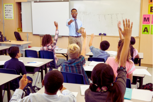 students raising hands in class