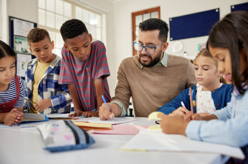 teacher working with group of elementary students